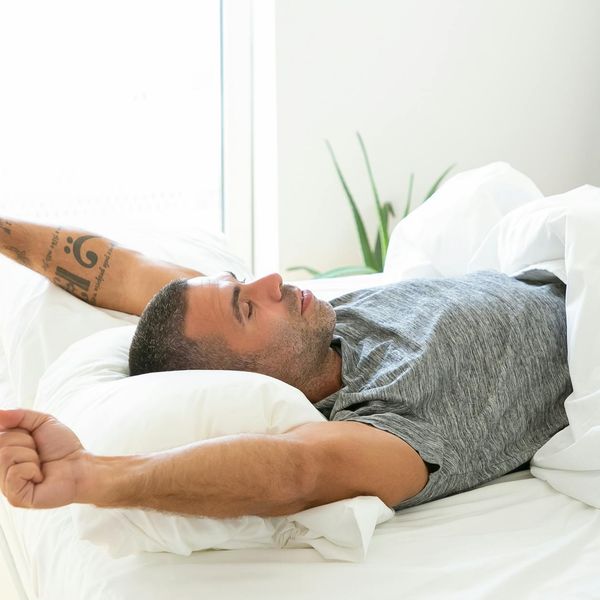 Person stretching near a window with morning light, feeling refreshed.